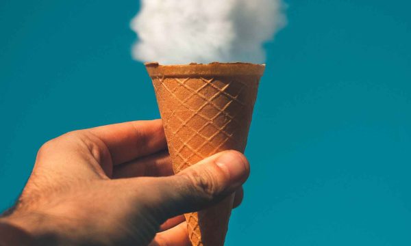 Hand mit Eiswaffel und Wolke